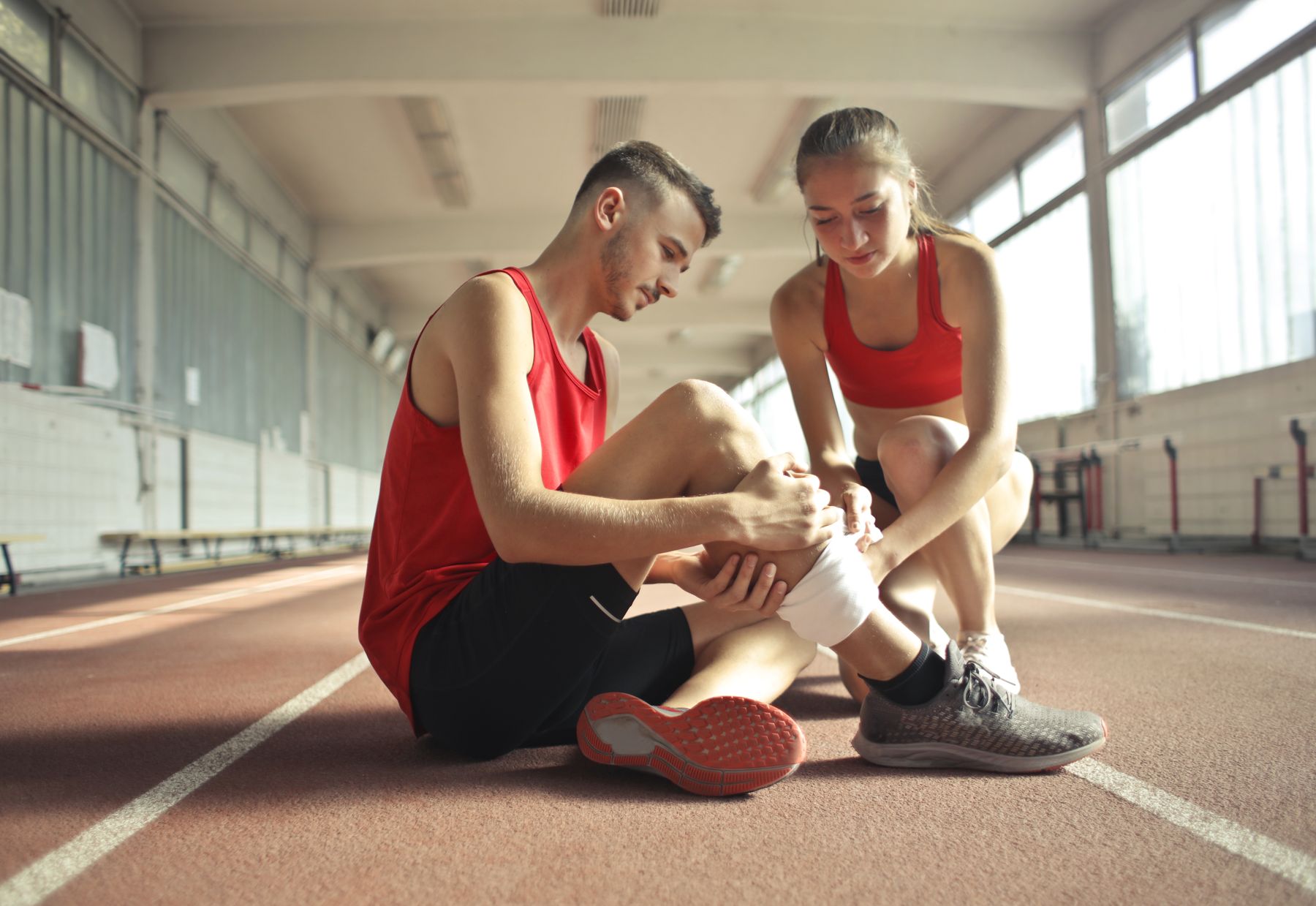 Athlete having a sprained ankle wrapped trackside