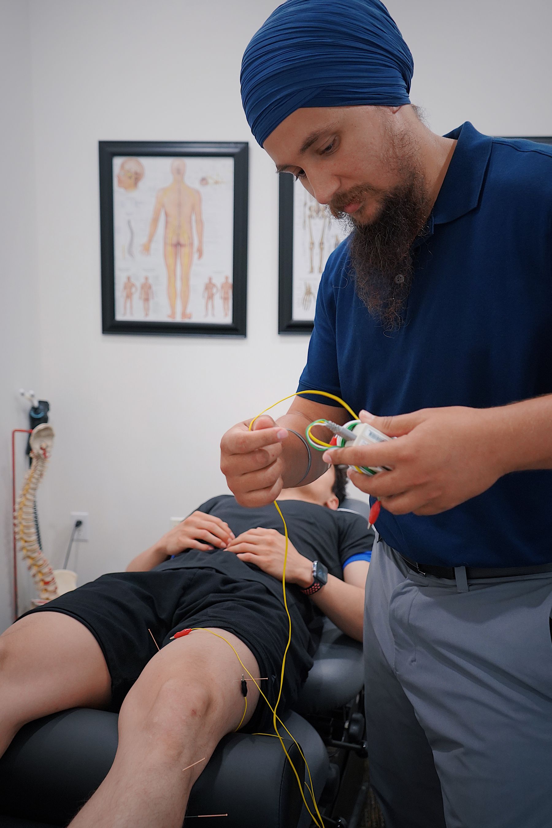 Clinician setting up electrode-based muscle feedback during a knee rehabilitation session