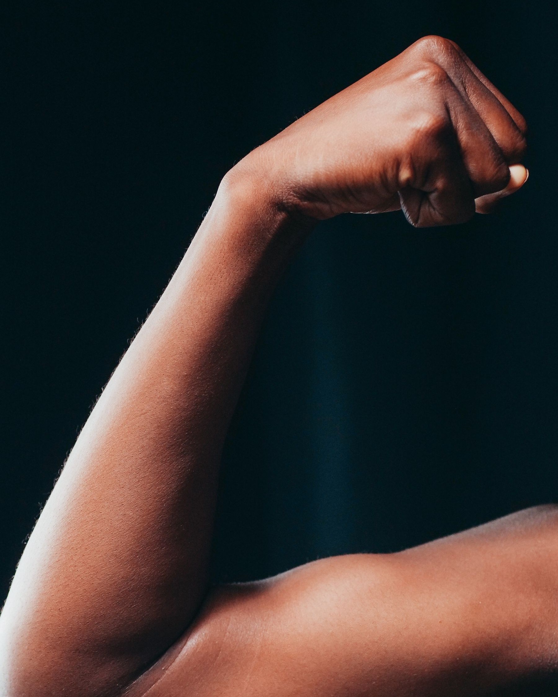 Clenched fist and forearm showing the flexor muscles that attach at the inside of the elbow