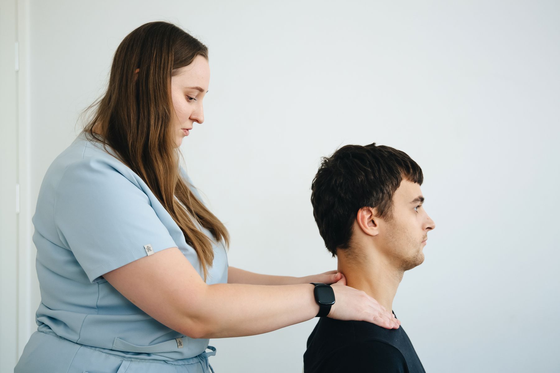 Physical therapist treating a patient's neck in the clinic