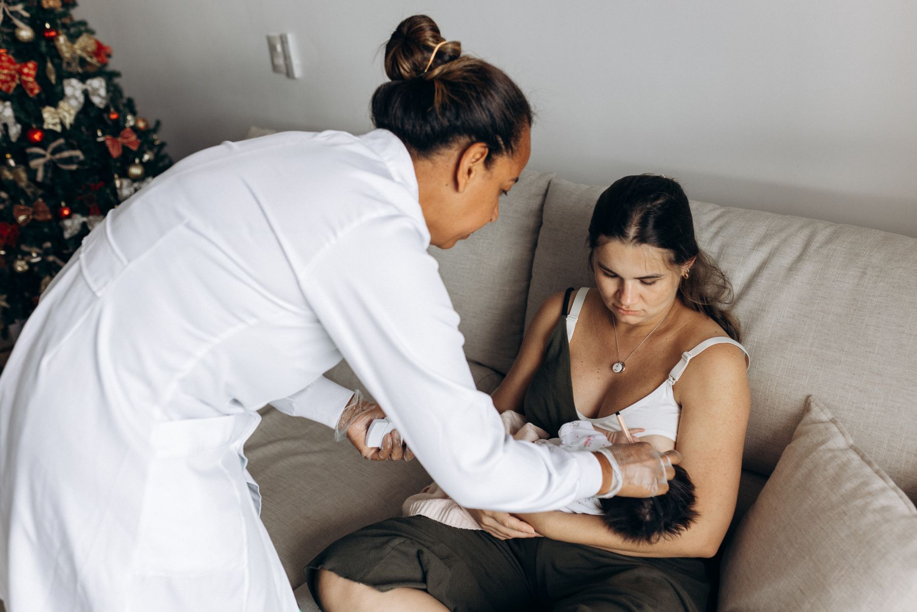 Healthcare provider supporting a new mother holding her baby