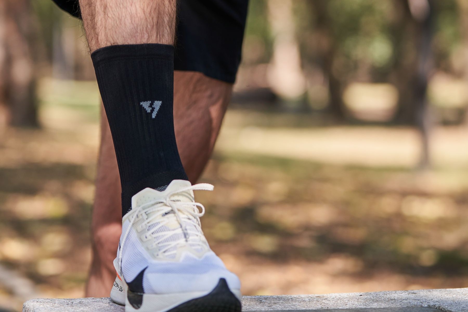 Runner resting a foot on a stone bench after a run, the pause that focal bone pain forces