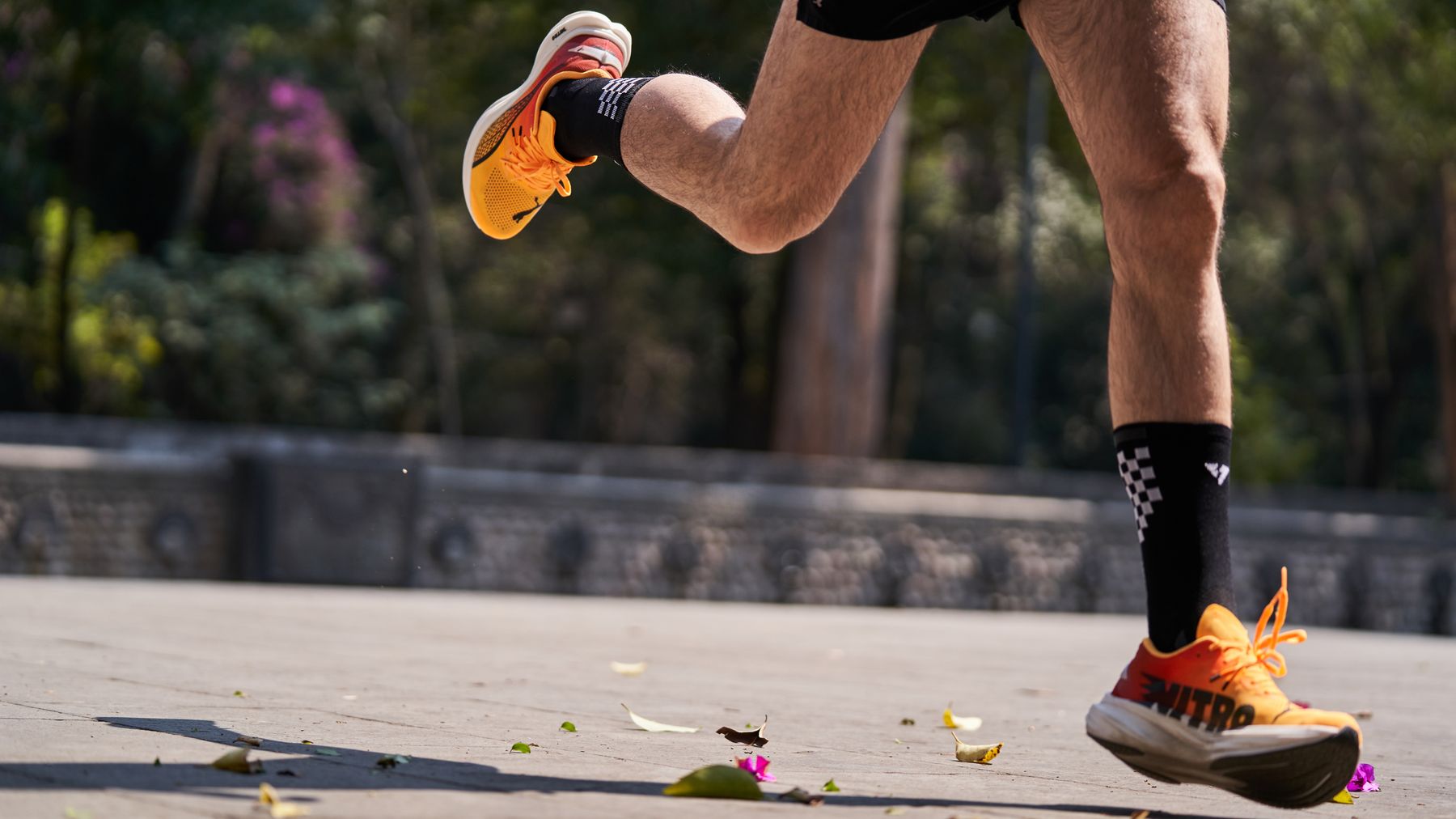 Runner's lower legs mid-stride on pavement