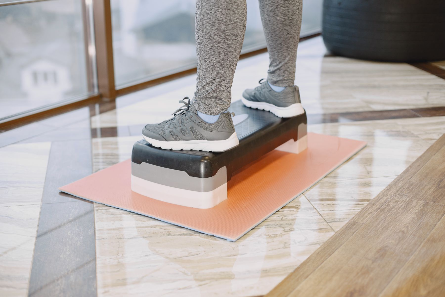 Person training on a step platform during knee rehabilitation