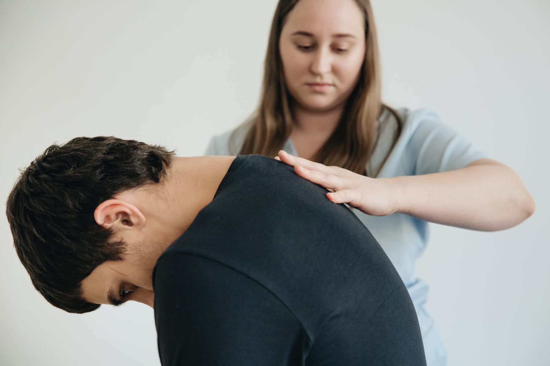 Physical therapist assessing neck movement in a patient with headaches