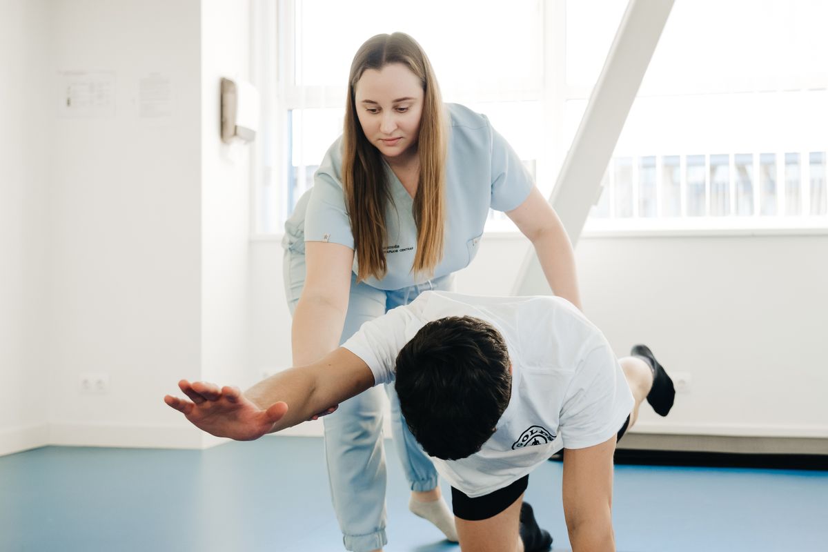 Physical therapist guiding a patient through an assisted leg stretch