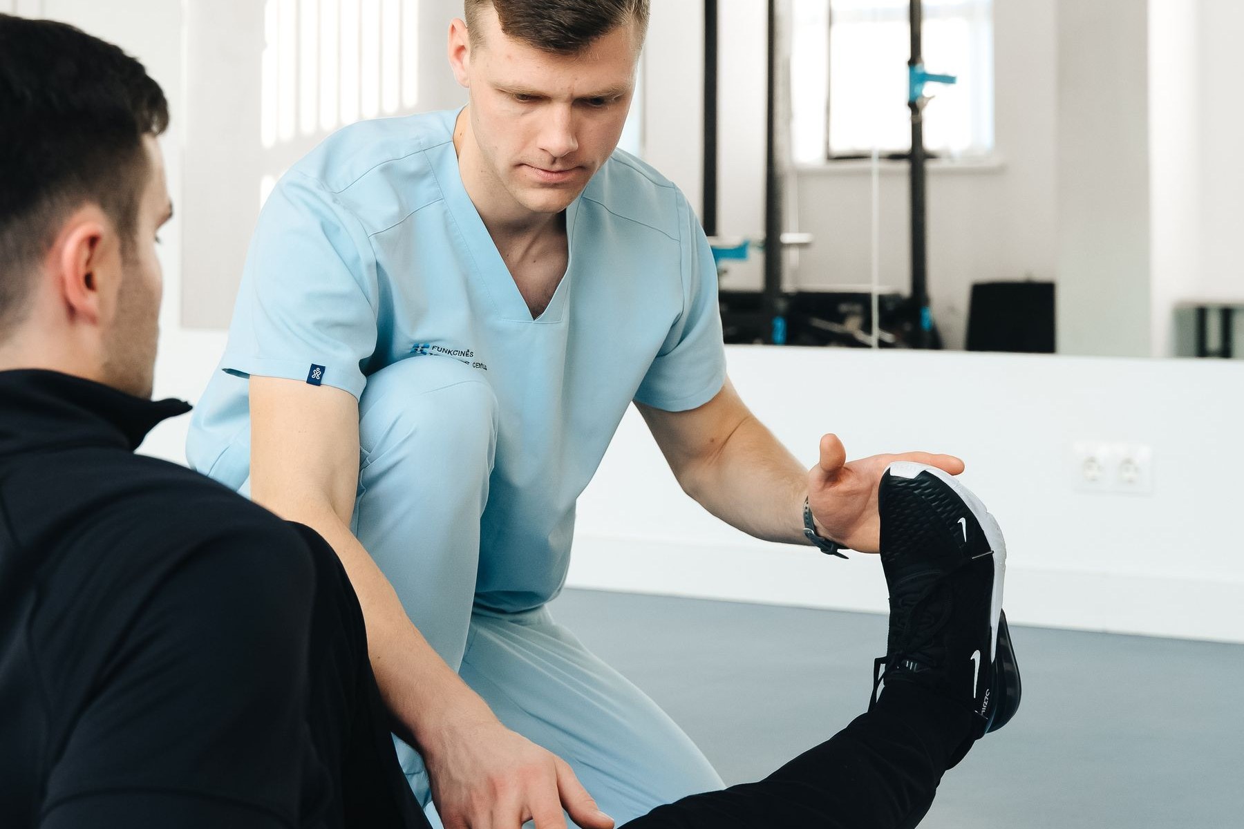 Physical therapist measuring hip flexion and rotation range of motion during a hip arthritis assessment
