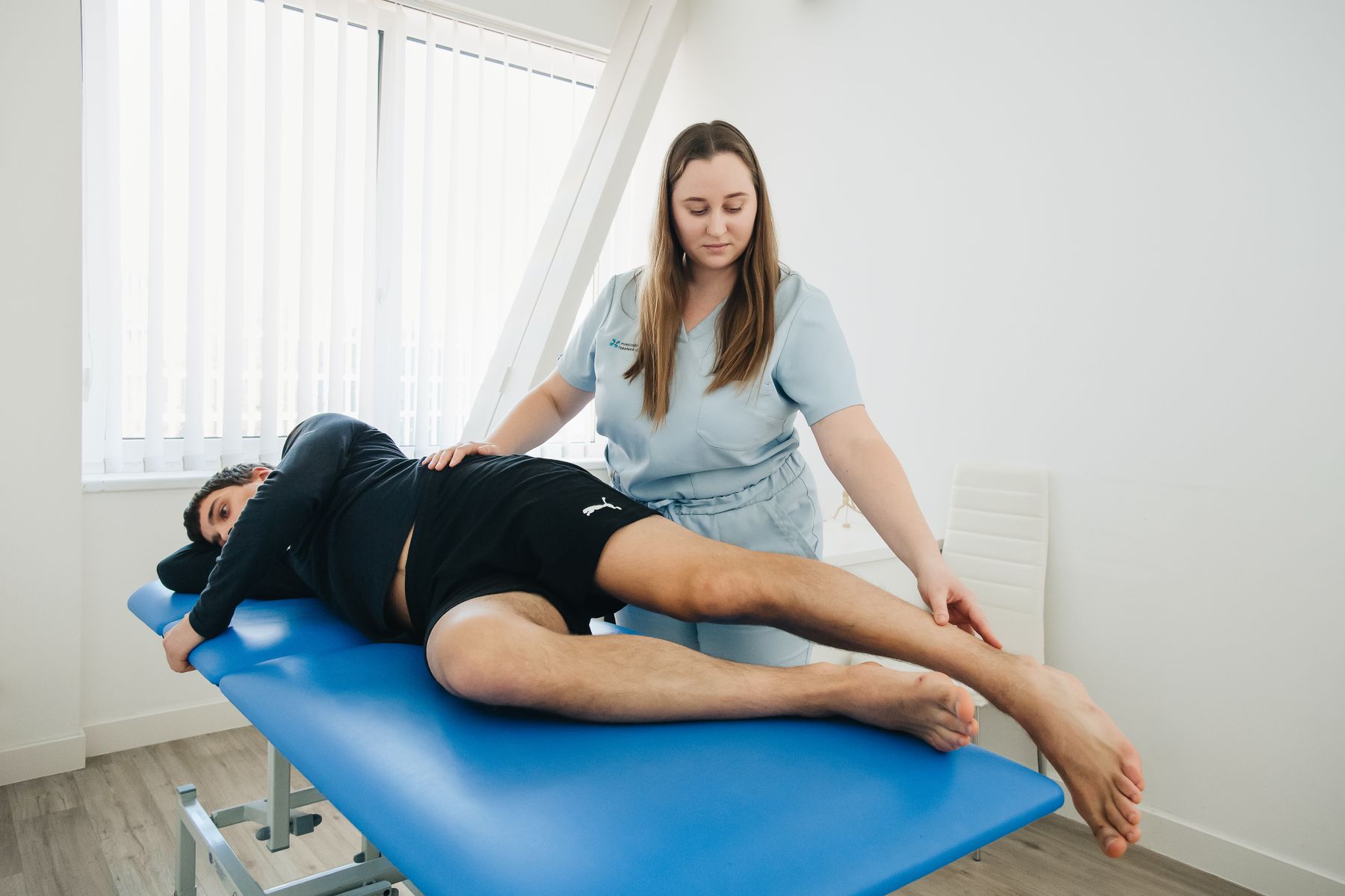 Physical therapist performing hands-on hip and thigh treatment for a patient with hip osteoarthritis