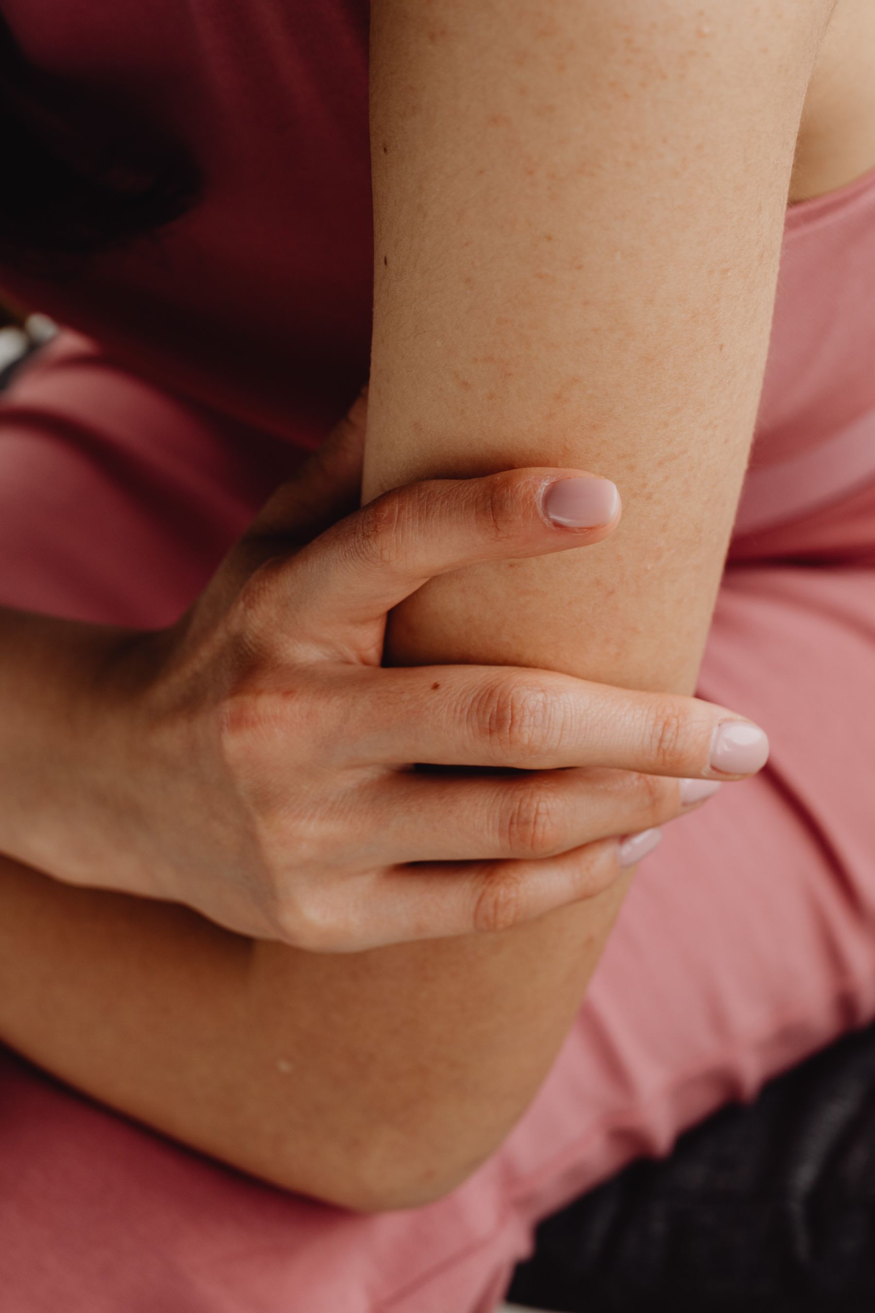 Woman holding her painful elbow