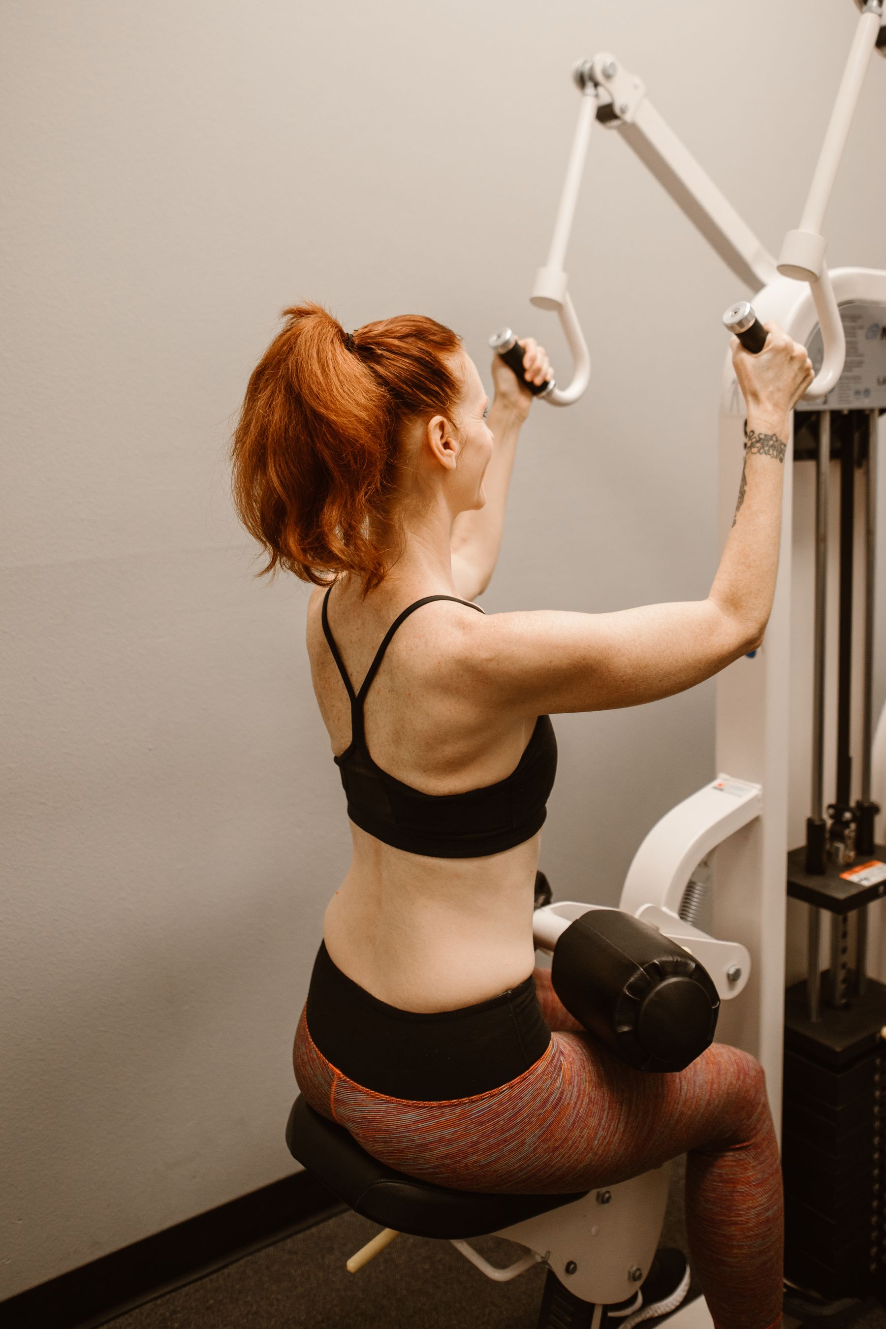Woman training on a lat pulldown machine in the gym